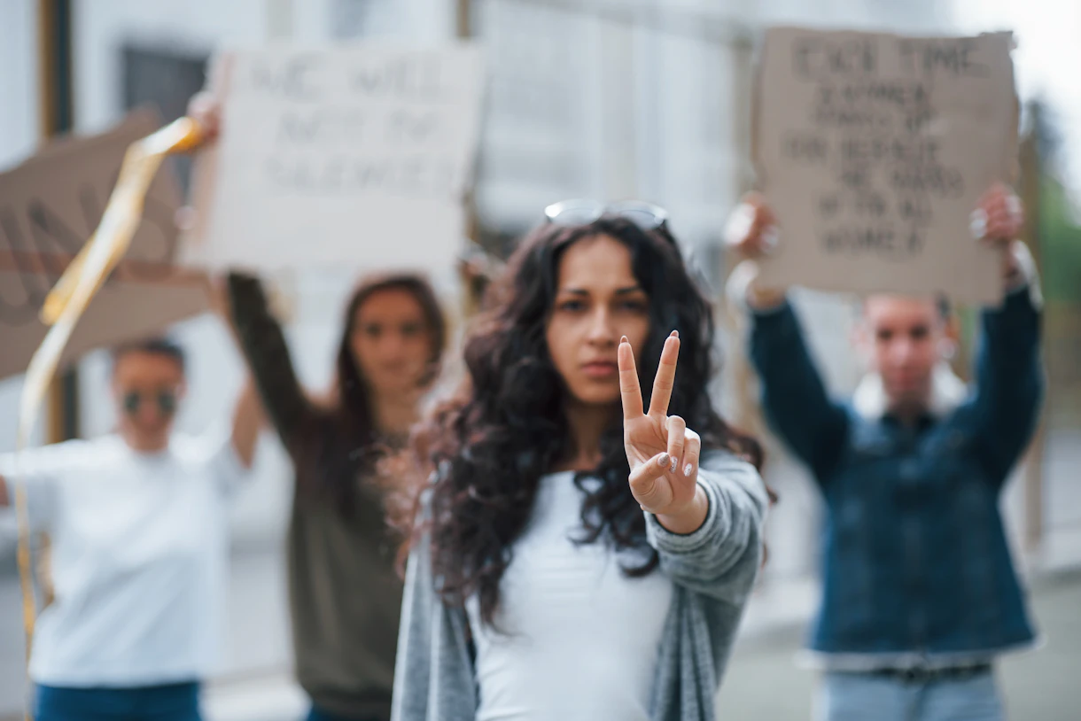 Showing gesture by two fingers group feminist women have protest their rights outdoors